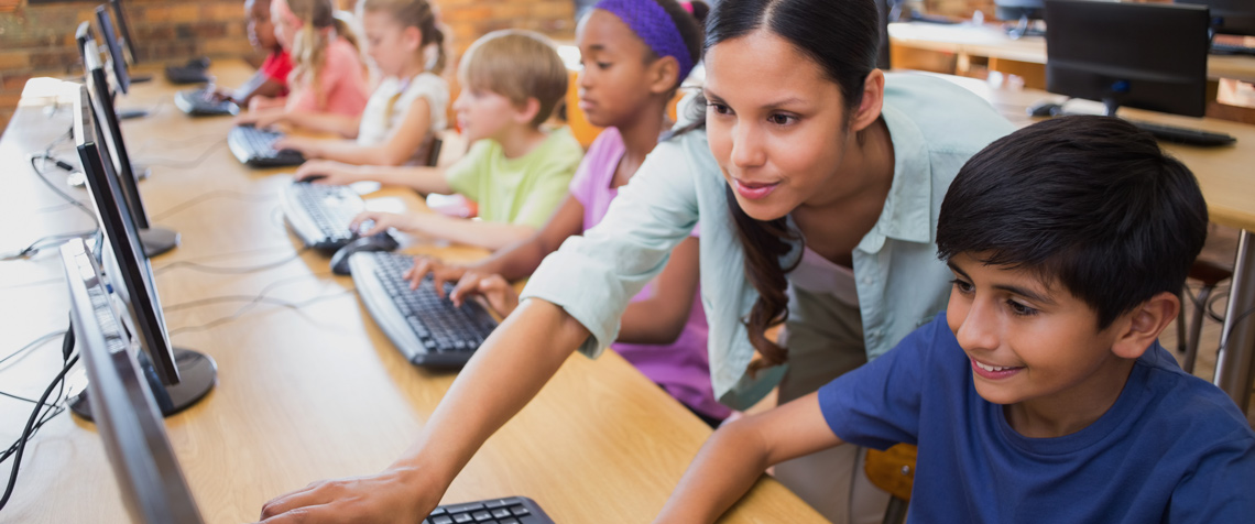 teacher with student at a computer