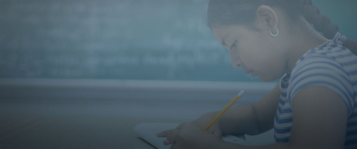 student writing at her desk